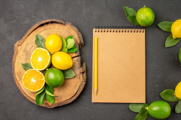 Vista superior limones agrios frescos en mesa de color gris oscuro frutas cítricos lima