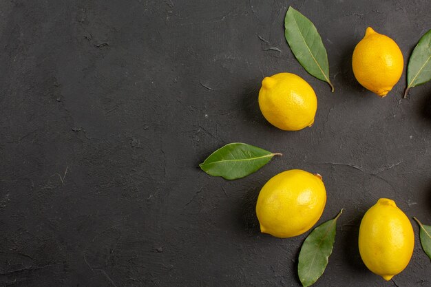 Vista superior de limones amargos frescos forrados en la mesa oscura fruta cítricos limón amarillo