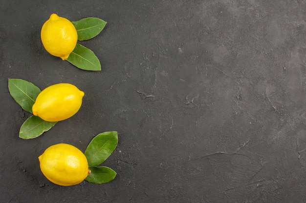 Vista superior de limones amargos frescos en la mesa oscura fruta amarilla cítrica lima