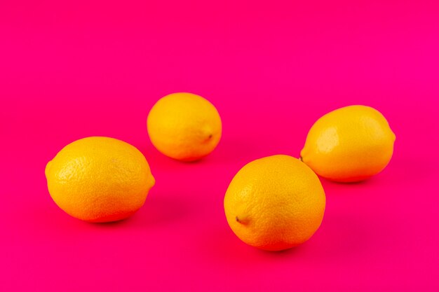 Una vista superior limones amarillos aislados limones maduros jugosos frescos en el fondo rosa cítricos frescos