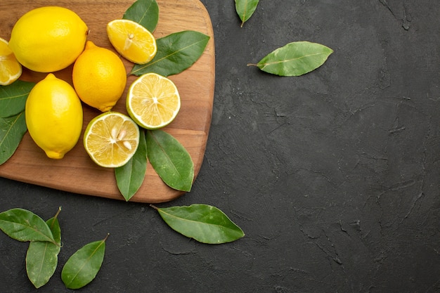 Vista superior de limones frescos frutas ácidas en frutas cítricas de mesa oscura