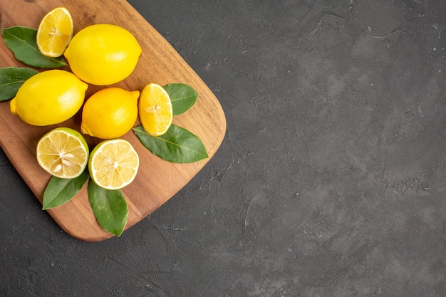 Vista superior de limones frescos frutas ácidas en la mesa de color gris oscuro cítricos lima