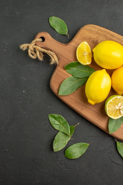 Vista superior limones frescos frutas ácidas en mesa oscura cítricos lima madura