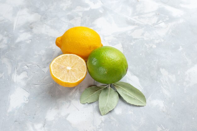 Vista superior de limones frescos jugosos y agrios en el escritorio blanco cítricos de frutas exóticas tropicales