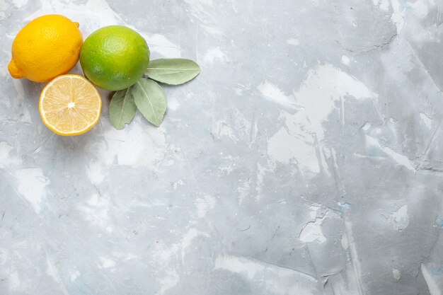Vista superior de limones frescos jugosos y agrios en el escritorio blanco cítricos de frutas exóticas tropicales