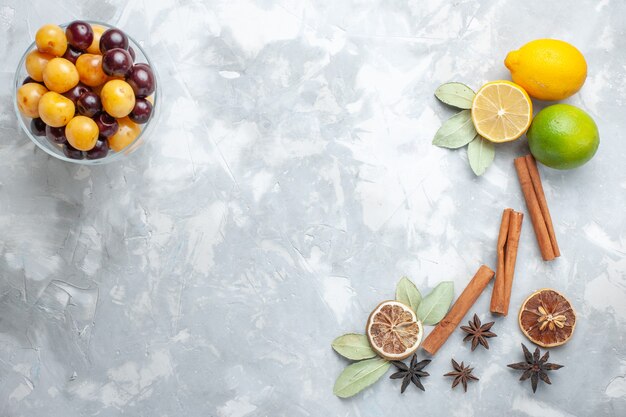 Vista superior de limones frescos jugosos y amargos con cerezas de canela en el escritorio blanco cítricos de frutas exóticas tropicales