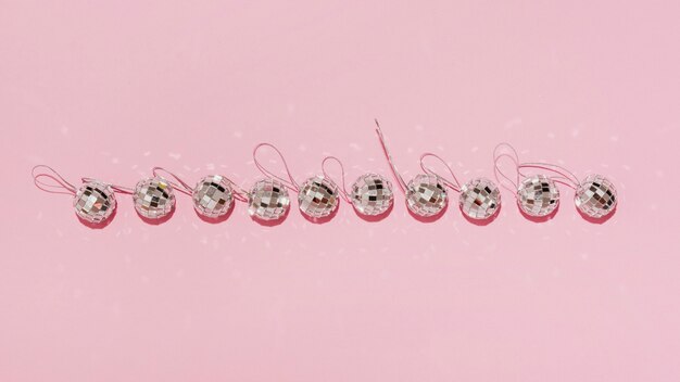 Vista superior de la línea horizontal de bolas de navidad sobre fondo rosa