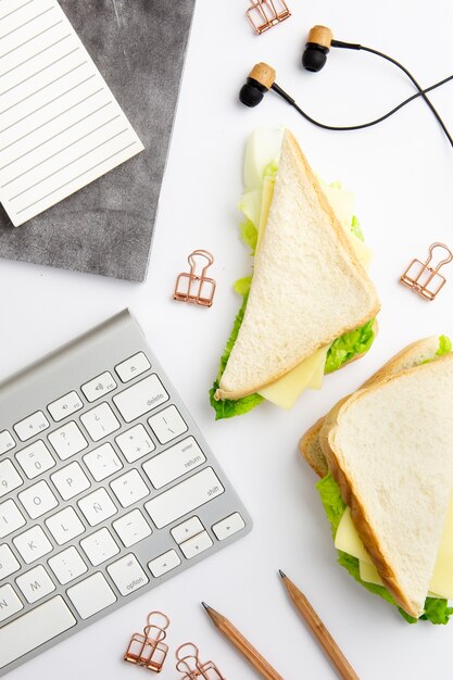 Vista superior del lugar de trabajo con plato de deliciosos sándwiches