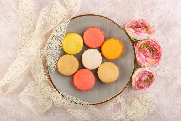 Una vista superior de macarons franceses coloreados con flor dentro de la placa