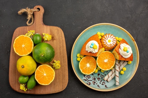 Vista superior de mandarinas frescas con feijoa y rebanadas de pastel en negro