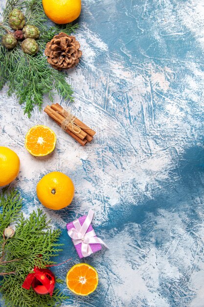 Vista superior mandarinas frescas con regalos sobre fondo azul.