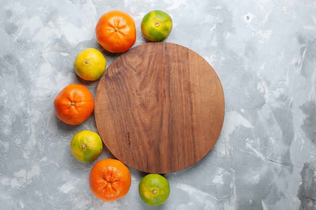 Vista superior mandarinas jugosas frescas cítricos suaves en el escritorio de color blanco claro cítricos tropicales exóticos