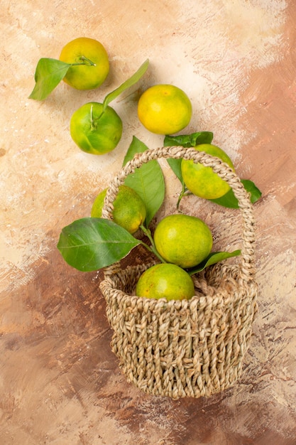 Vista superior mandarinas verdes frescas dentro de la cesta sobre el fondo claro