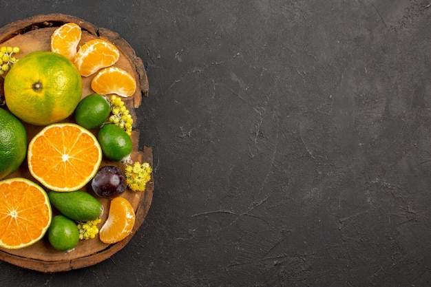 Vista superior de mandarinas verdes frescas con feijoas en la oscuridad