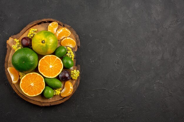 Vista superior de mandarinas verdes frescas con feijoas en la oscuridad