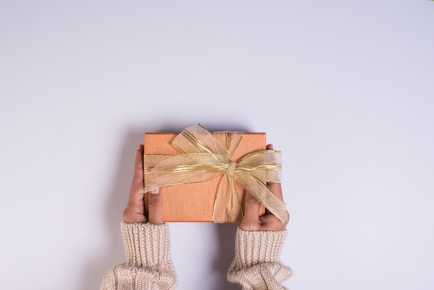 Vista superior de la mano con caja de regalo en el espacio de trabajo