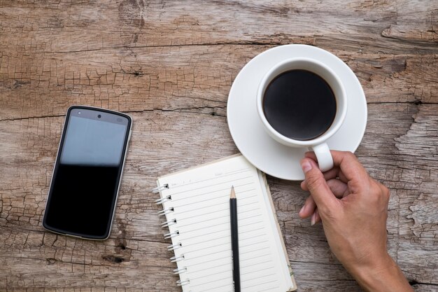 Vista superior de la mano de la mujer sosteniendo una taza de café,