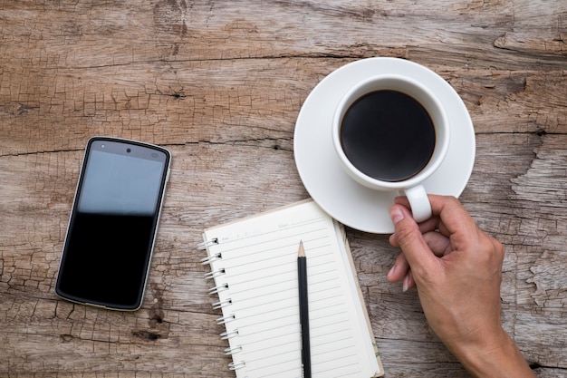 Vista superior de la mano de la mujer sosteniendo una taza de café,