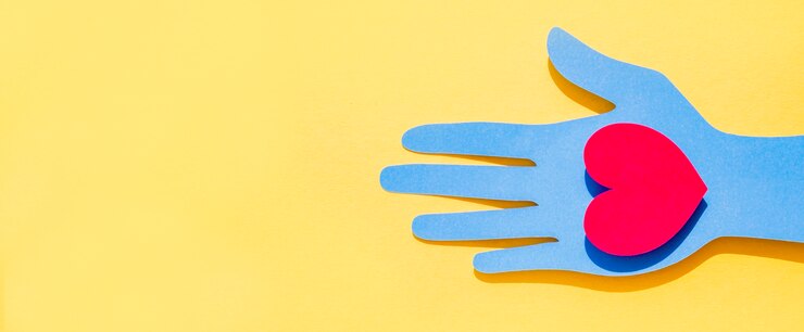 Foto gratuito vista superior de la mano de papel sosteniendo el corazón con espacio de copia