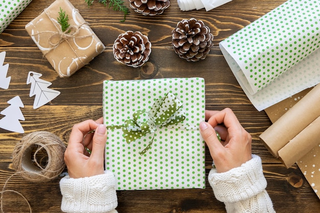 Vista superior de las manos atando el regalo de Navidad con una cuerda