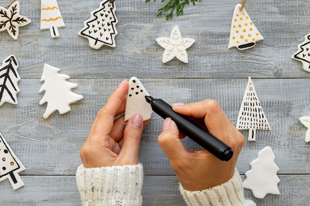 Vista superior de las manos dibujando en las decoraciones del árbol de Navidad