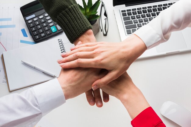 Vista superior de las manos juntas sobre la mesa de trabajo