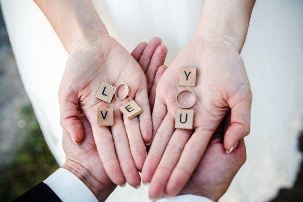 Vista superior de las manos de la novia con los anillos de boda