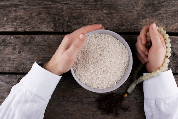 Vista superior de manos con plato de arroz.