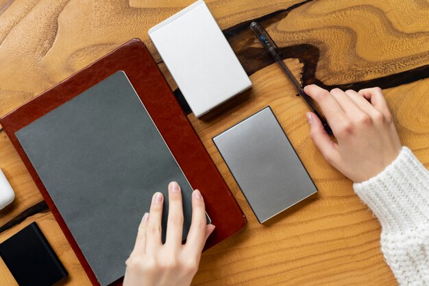 Vista superior manos sosteniendo bolígrafo y cuaderno