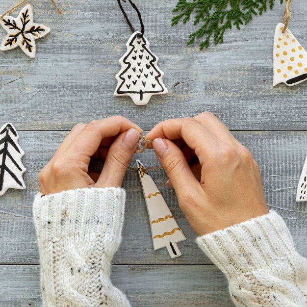 Vista superior de las manos trabajando en la decoración del árbol de Navidad