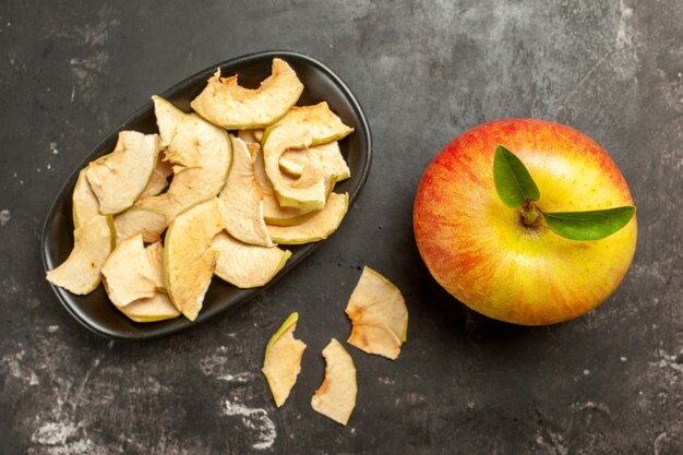 Vista superior de manzana fresca con manzana seca sobre fondo oscuro