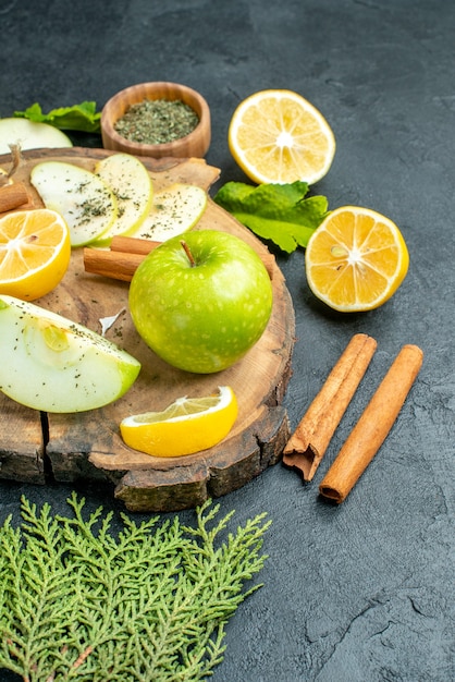 Foto gratuita vista superior de manzana verde fresca sobre tablero de madera con polvo de menta seca en un tazón de canela sobre mesa negra