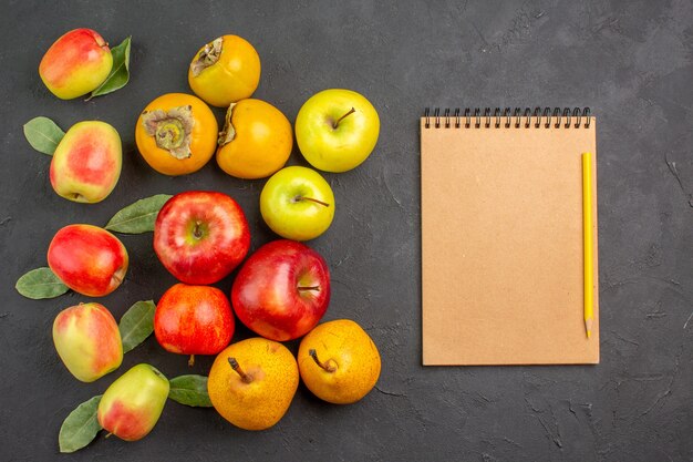 Vista superior de manzanas frescas con caquis y peras en la mesa oscura suave árbol maduro fresco