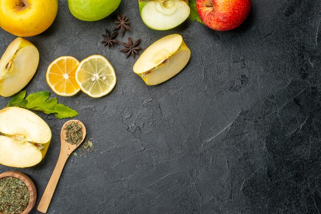 Vista superior de manzanas frescas enteras y en rodajas de color verde amarillo en el lado derecho sobre un fondo oscuro