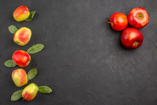 Vista superior de manzanas frescas con hojas verdes en la mesa oscura madura fresca suave