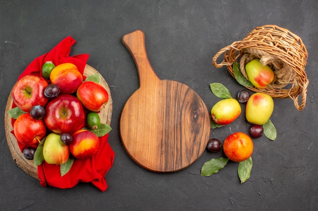 Vista superior de manzanas frescas con melocotones y ciruelas en la mesa oscura árbol de jugo maduro suave