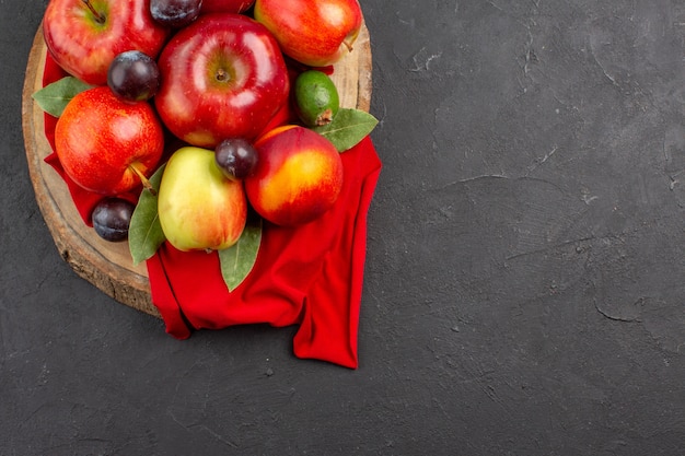 Vista superior de manzanas frescas con melocotones y ciruelas en la mesa oscura árbol de jugo suave de fruta madura