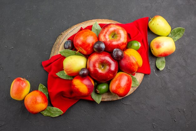 Vista superior de manzanas frescas con melocotones y ciruelas en la mesa oscura árbol maduro suave