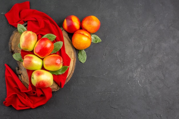 Foto gratuita vista superior de manzanas frescas con melocotones en el color oscuro de la mesa fruta madura fresca