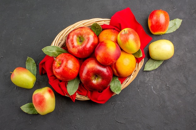 Vista superior de manzanas frescas con melocotones dentro de la canasta en la mesa oscura árbol de frutas maduras frescas