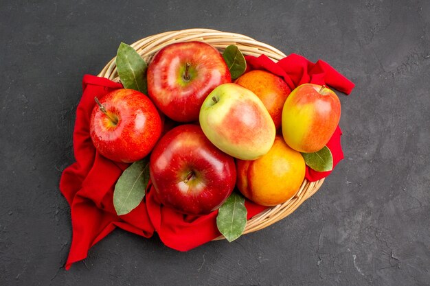 Vista superior de manzanas frescas con melocotones en la mesa oscura color fruta fresca madura