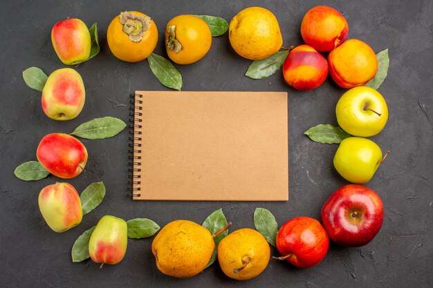 Foto gratuita vista superior de manzanas frescas con peras y caquis en una mesa oscura madura fresca suave