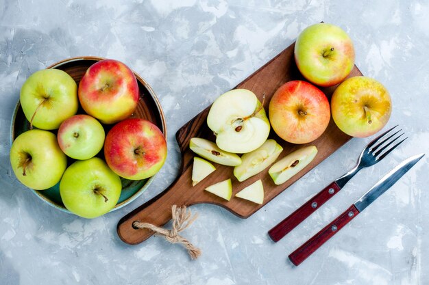 Vista superior de manzanas frescas en rodajas de frutas enteras sobre la superficie de color blanco claro