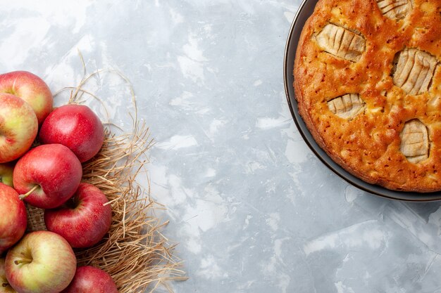 Foto gratuita vista superior de manzanas frescas suaves y maduras con tarta de manzana en el piso blanco jugo suave de frutas color maduro