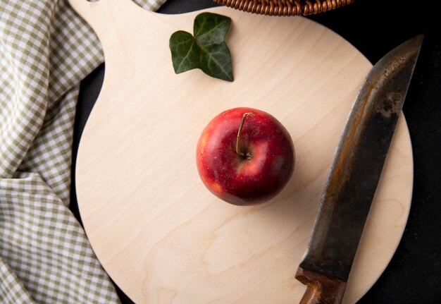 Vista superior de manzanas rojas y un cuchillo en el tablero