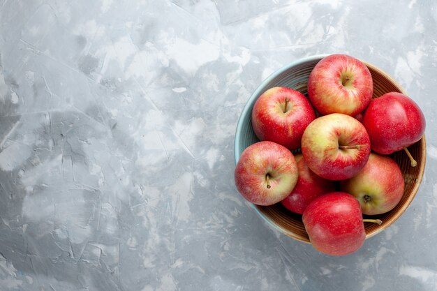 Vista superior de las manzanas rojas frescas dentro de la placa sobre fondo blanco fruta fresca vitamina madura suave