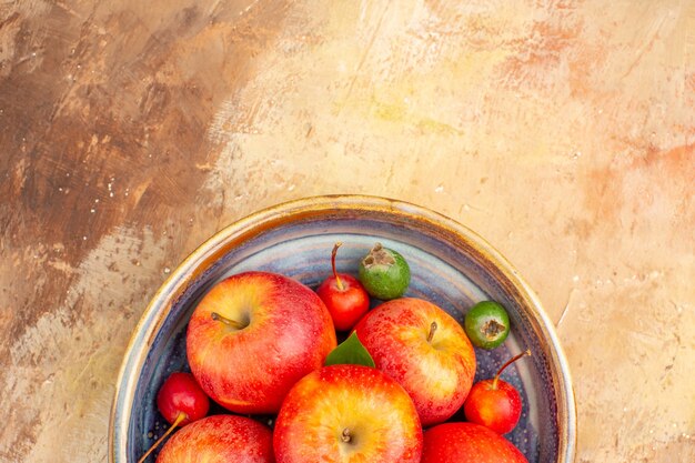 Vista superior de manzanas rojas frescas con feijoas dentro de la bandeja