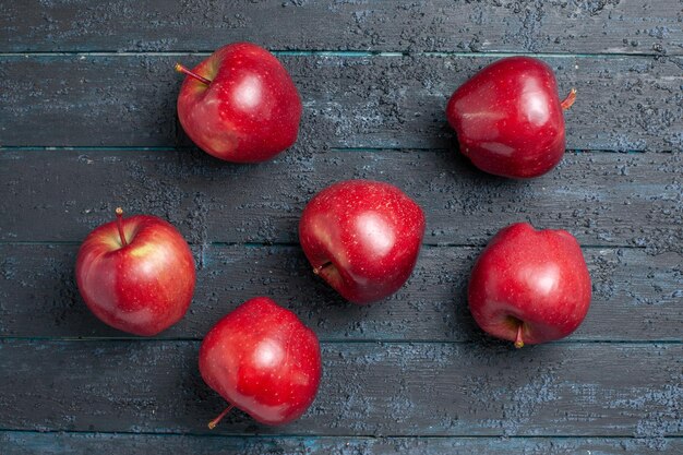 Vista superior de manzanas rojas frescas frutas maduras y suaves en el escritorio de color azul oscuro fruta colores enteros planta roja vitamina fresca