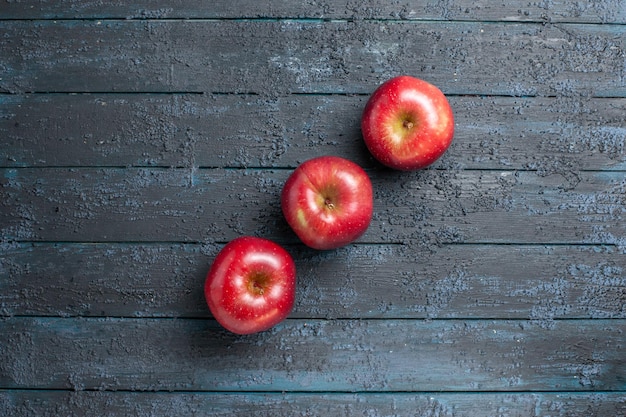 Vista superior de manzanas rojas frescas frutas maduras y suaves forradas en el escritorio azul oscuro muchas frutas rojo árbol de color de plantas frescas