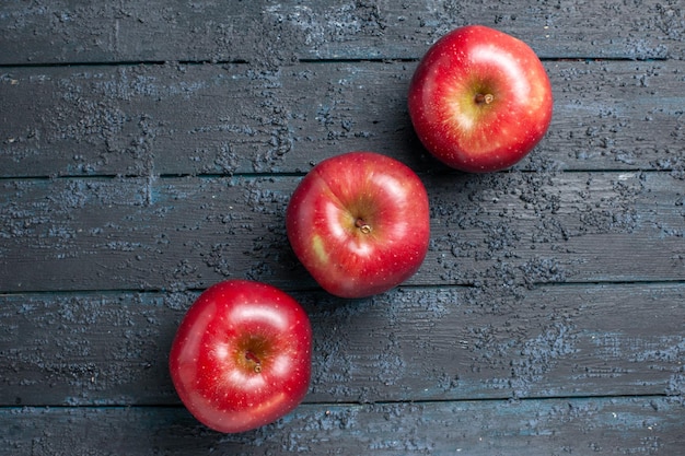 Vista superior de manzanas rojas frescas frutas maduras y suaves forradas en el escritorio azul oscuro muchas frutas rojo árbol de color de plantas frescas